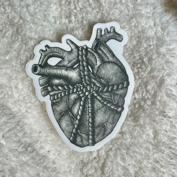 Black and white sticker featuring a detailed ink drawing of an anatomical human heart wrapped in string.