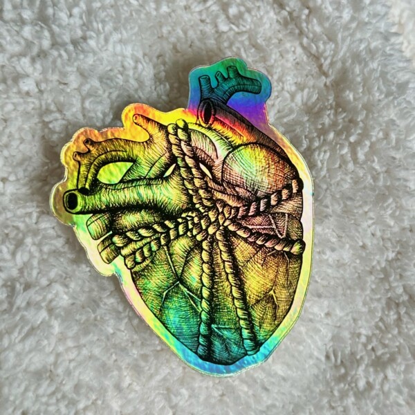 Holographic sticker of a detailed anatomical human heart ink drawing wrapped in string, reflecting rainbow colors.