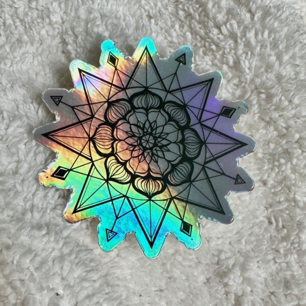 Holographic sticker featuring a symmetrical geometric mandala design with overlapping lines, arrows, and floral patterns.
